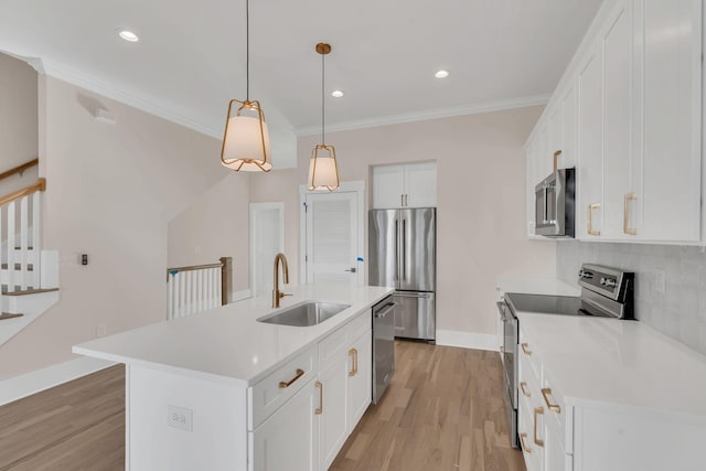 kitchen featuring hanging light fixtures, sink, an island with sink, appliances with stainless steel finishes, and white cabinetry