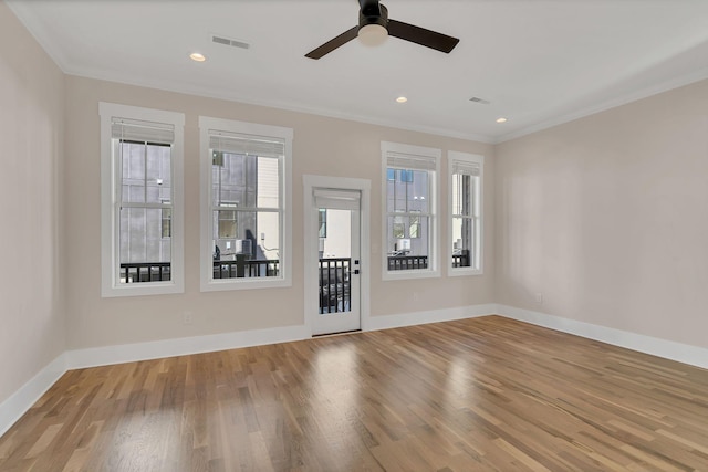 empty room with light wood-type flooring, ceiling fan, and ornamental molding