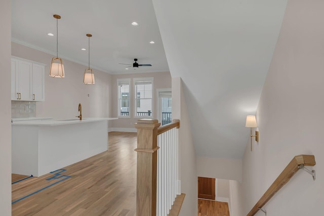 stairs with hardwood / wood-style flooring, ceiling fan, and crown molding