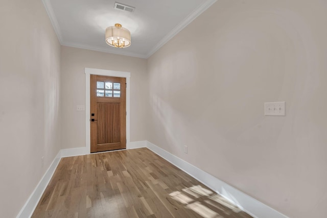 entryway with light hardwood / wood-style flooring and crown molding