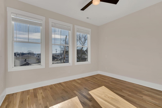 empty room with hardwood / wood-style floors and ceiling fan