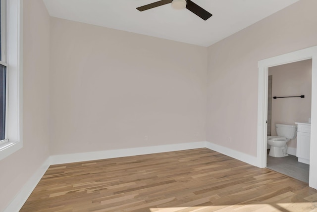 unfurnished bedroom with connected bathroom, light hardwood / wood-style floors, and ceiling fan