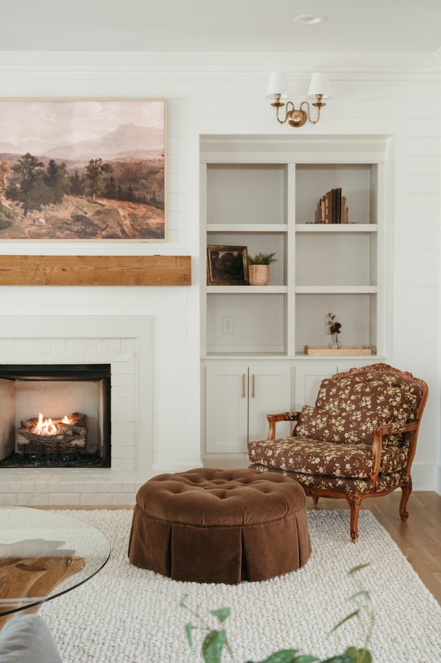 living area with hardwood / wood-style floors and a brick fireplace