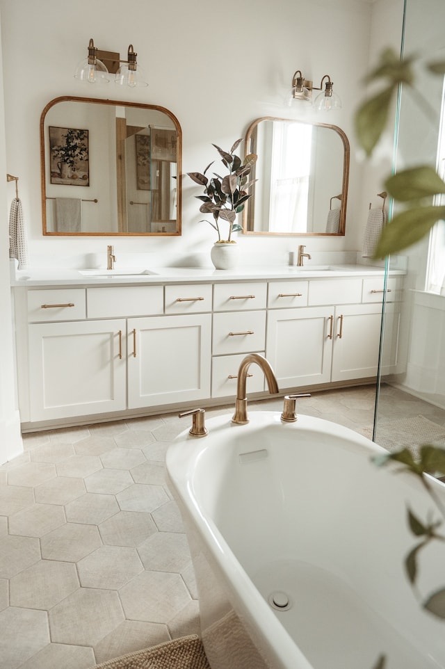 bathroom with vanity, tile patterned floors, and tiled bath