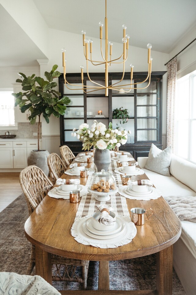 dining space with sink, a chandelier, and wood-type flooring