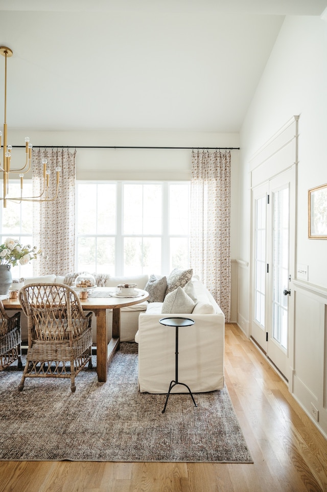 living room featuring a chandelier, lofted ceiling, hardwood / wood-style floors, and a healthy amount of sunlight