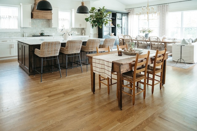 dining room with light hardwood / wood-style floors, an inviting chandelier, and plenty of natural light