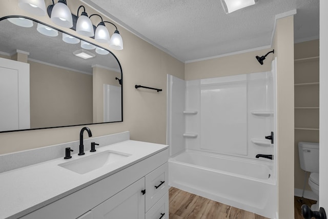 full bathroom with toilet, wood-type flooring, crown molding, vanity, and washtub / shower combination