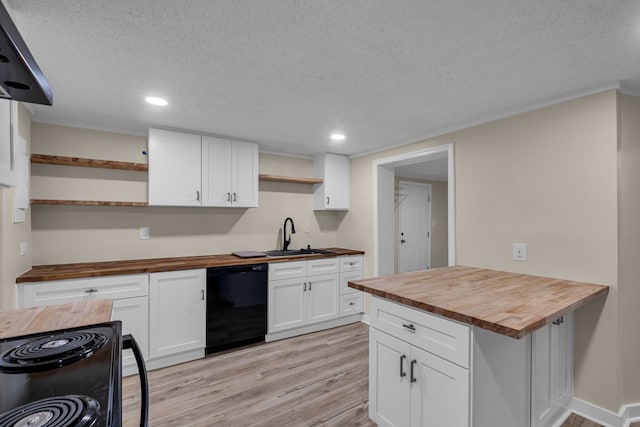 kitchen with wooden counters, sink, black appliances, white cabinets, and light hardwood / wood-style floors