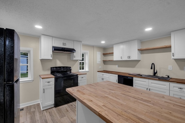 kitchen with butcher block countertops, black appliances, and white cabinets