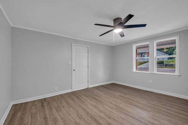 empty room with ceiling fan, hardwood / wood-style flooring, and ornamental molding