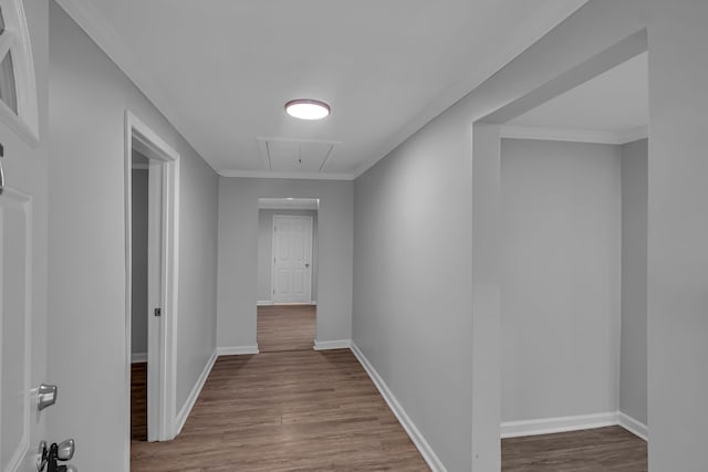 hall with ornamental molding and hardwood / wood-style floors