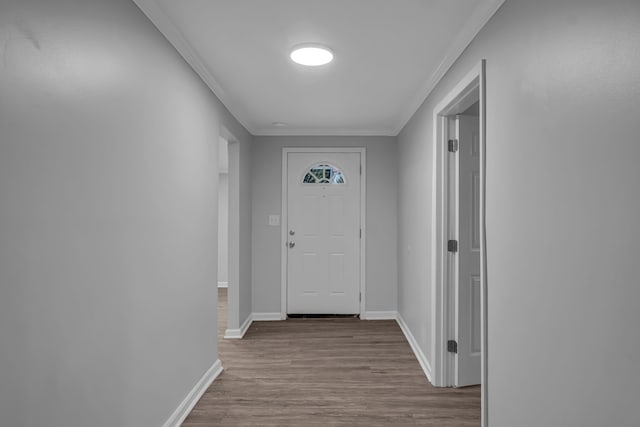 doorway featuring crown molding and hardwood / wood-style flooring