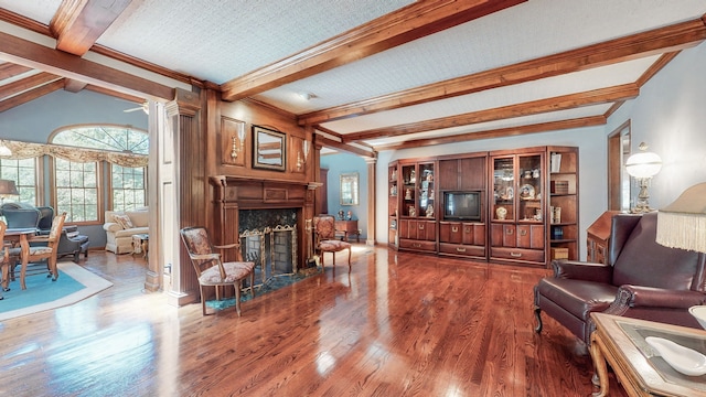 living room with vaulted ceiling with beams, a fireplace, decorative columns, hardwood / wood-style floors, and ornamental molding