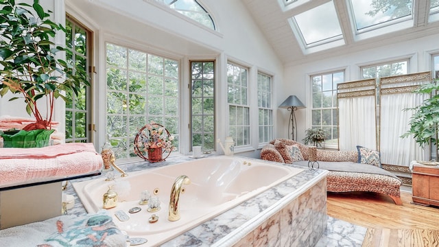 sunroom / solarium with vaulted ceiling with skylight and a healthy amount of sunlight