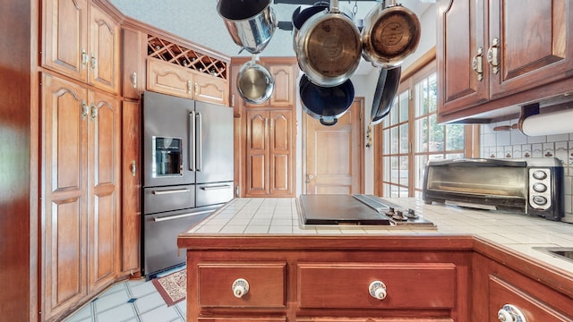 kitchen featuring tile countertops, decorative backsplash, and stainless steel appliances