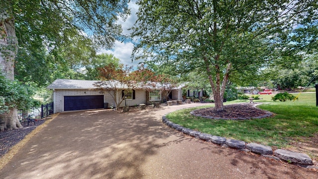 ranch-style house featuring a front yard and a garage