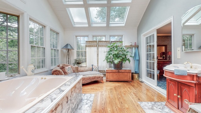 sunroom / solarium featuring vaulted ceiling with skylight and sink