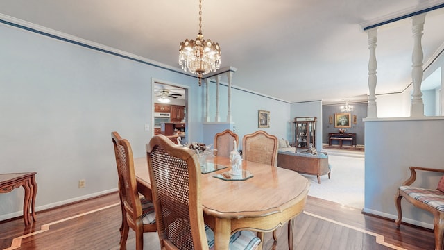 dining area with crown molding, hardwood / wood-style flooring, and ceiling fan with notable chandelier