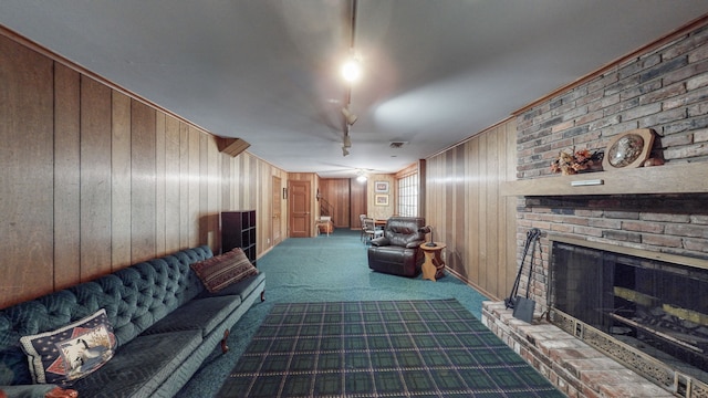 living room featuring crown molding, wood walls, carpet, and a brick fireplace