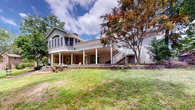 back of property with a yard and a deck