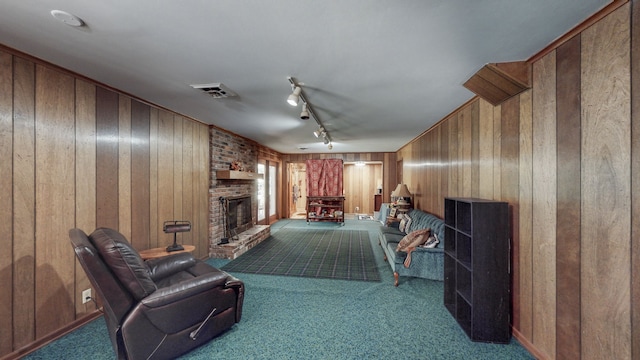 living room with rail lighting, carpet floors, wooden walls, and a fireplace