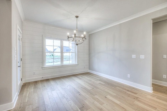 unfurnished dining area featuring ornamental molding, light hardwood / wood-style floors, and a notable chandelier