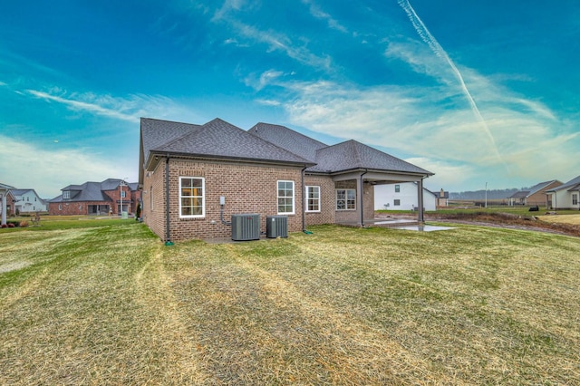 back of property featuring a yard, central AC unit, and a patio