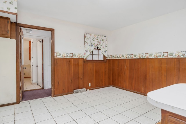 tiled spare room with wood walls