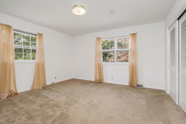 unfurnished bedroom featuring light carpet and a closet