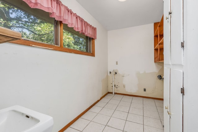 clothes washing area with light tile patterned floors