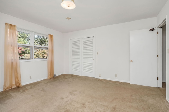 unfurnished bedroom with a closet and light carpet