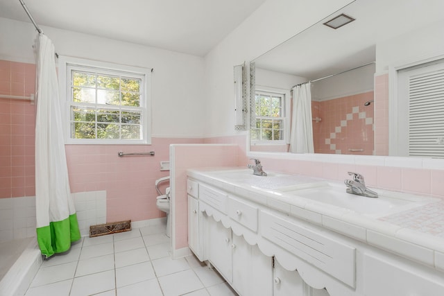 bathroom with a healthy amount of sunlight, vanity, toilet, and tile patterned floors