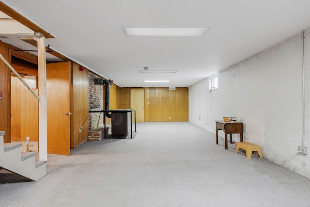 basement with wood walls and light colored carpet