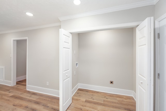 interior space featuring ornamental molding, a textured ceiling, and light hardwood / wood-style floors