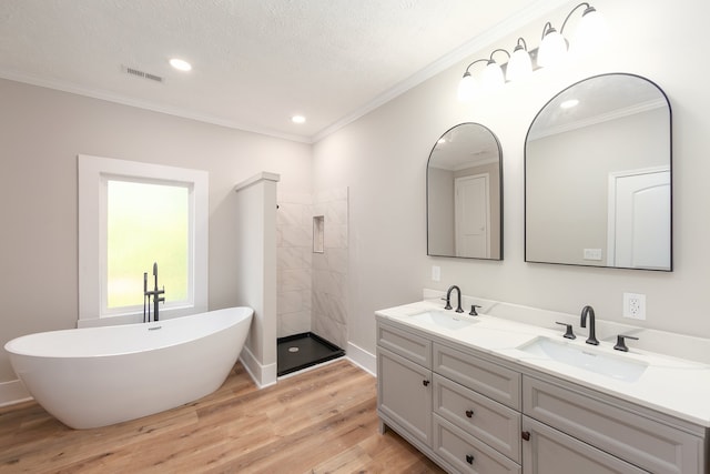 bathroom featuring a textured ceiling, independent shower and bath, wood-type flooring, vanity, and crown molding