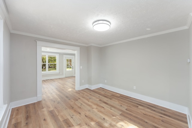 spare room with light hardwood / wood-style floors, crown molding, and a textured ceiling