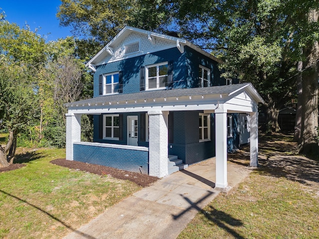 view of front of home with covered porch and a front lawn