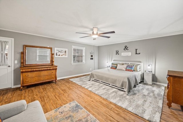 bedroom featuring ornamental molding, light wood-type flooring, and ceiling fan