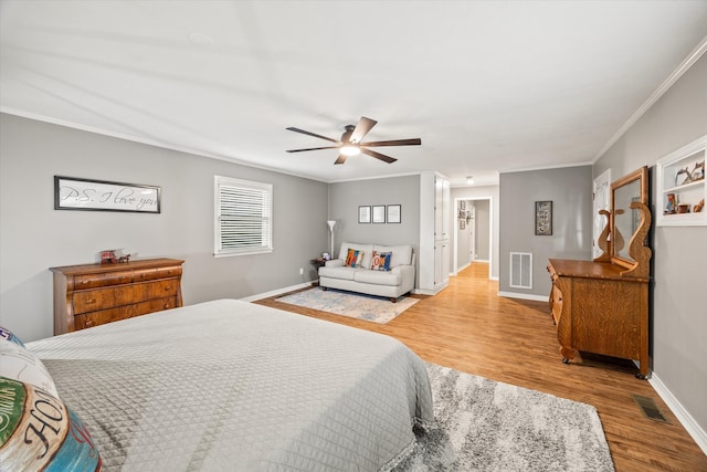 bedroom with crown molding, light hardwood / wood-style floors, and ceiling fan