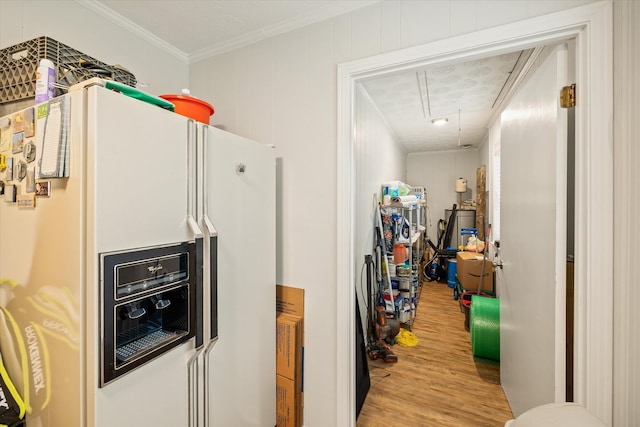 kitchen featuring ornamental molding, a textured ceiling, white refrigerator with ice dispenser, and wood-type flooring