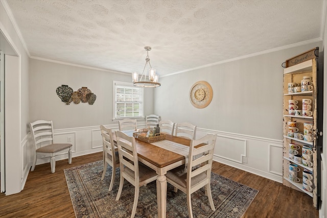 dining space with ornamental molding, dark wood-type flooring, a textured ceiling, and an inviting chandelier