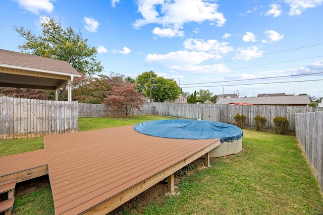 deck featuring a covered pool and a lawn