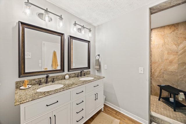 bathroom with vanity, a textured ceiling, and wood-type flooring