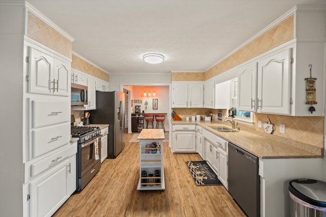 kitchen with sink, white cabinets, stainless steel appliances, and light hardwood / wood-style floors