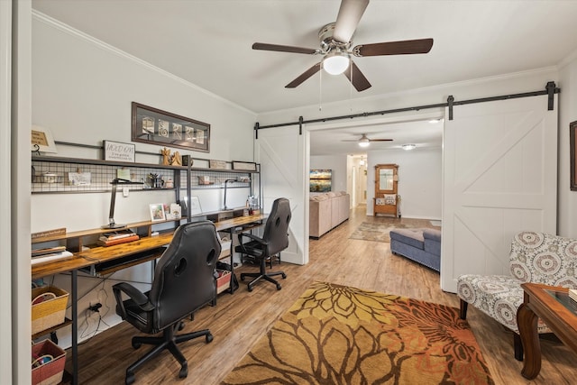 office space featuring ornamental molding, hardwood / wood-style floors, a barn door, and ceiling fan