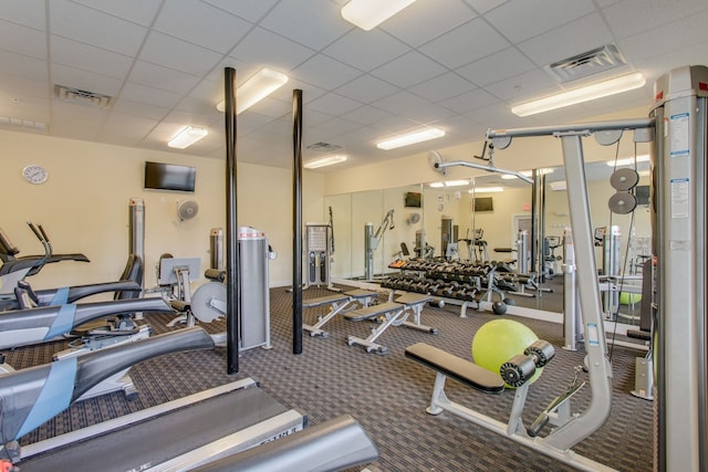 exercise room featuring a paneled ceiling and carpet floors