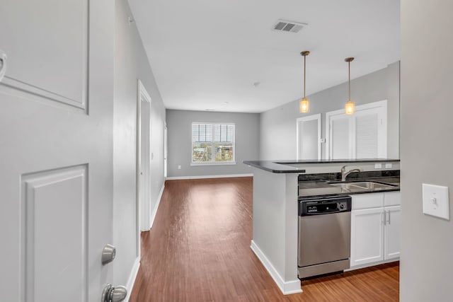 kitchen with pendant lighting, sink, stainless steel dishwasher, light wood-type flooring, and white cabinetry