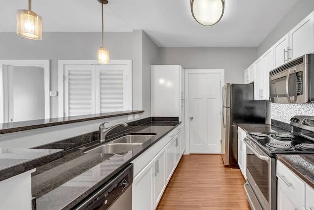 kitchen featuring pendant lighting, white cabinetry, sink, and appliances with stainless steel finishes