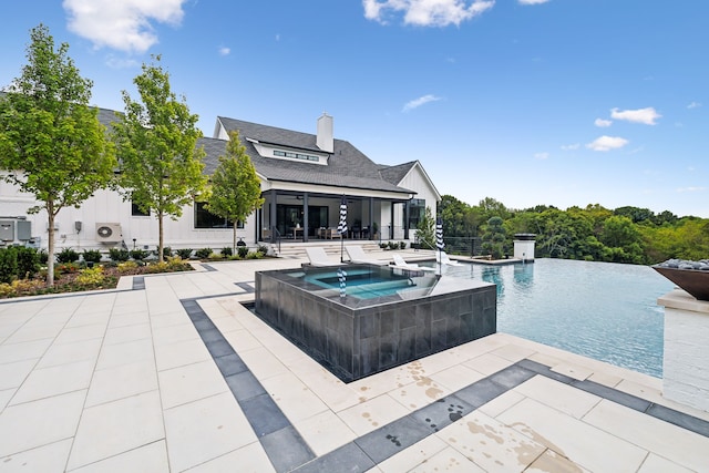 view of pool featuring a patio and an in ground hot tub